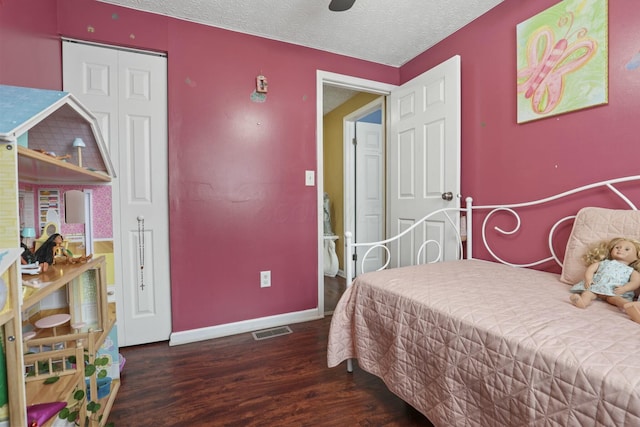 bedroom featuring ceiling fan, dark hardwood / wood-style floors, and a textured ceiling