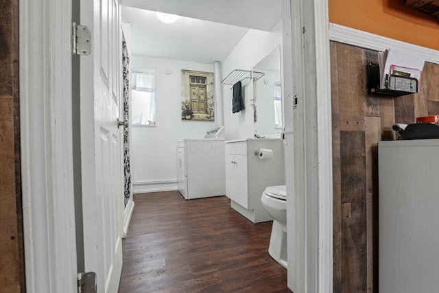 bathroom with hardwood / wood-style flooring, vanity, washing machine and clothes dryer, and toilet