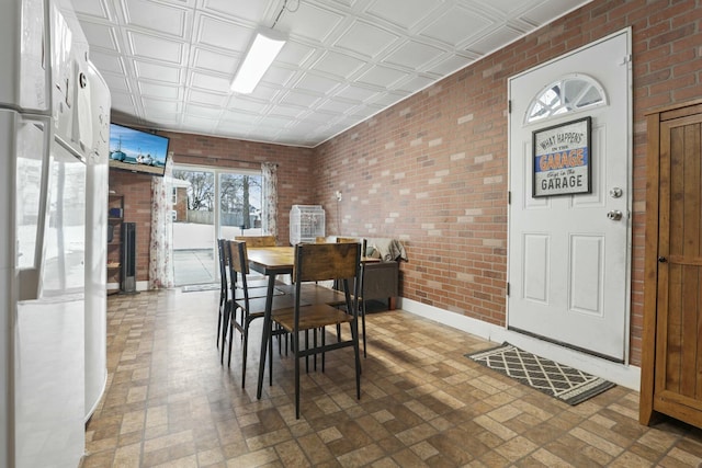 dining area featuring brick wall