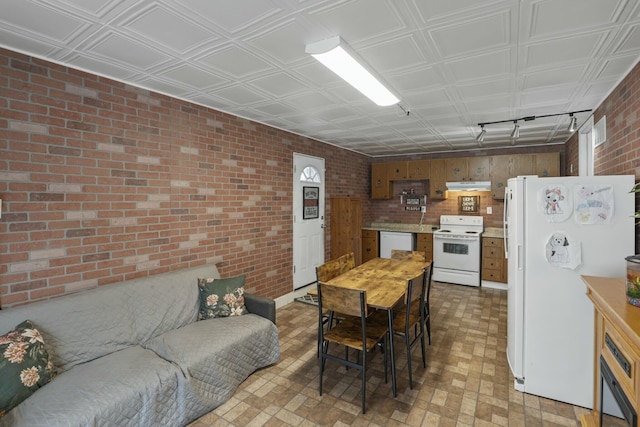 dining room featuring brick wall