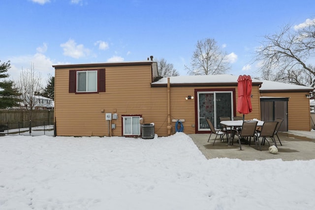 snow covered property with central AC