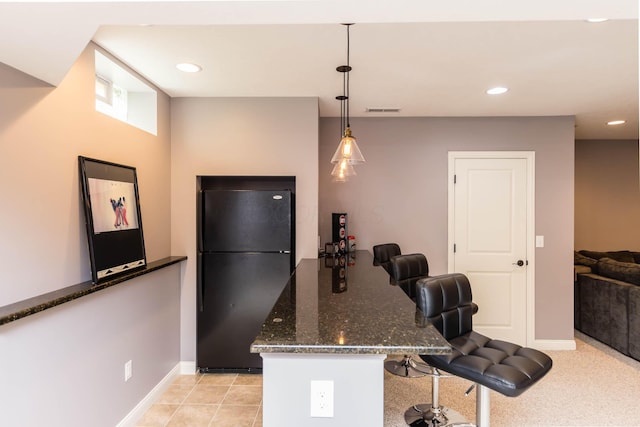 7201 Dean Farm Rd, New Albany, OH 43054 - kitchen featuring freestanding refrigerator, dark stone counters, baseboards, a breakfast bar area, and hanging light fixtures