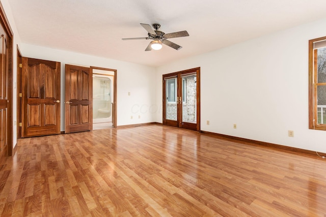 unfurnished room featuring a wealth of natural light, french doors, ceiling fan, and light hardwood / wood-style floors