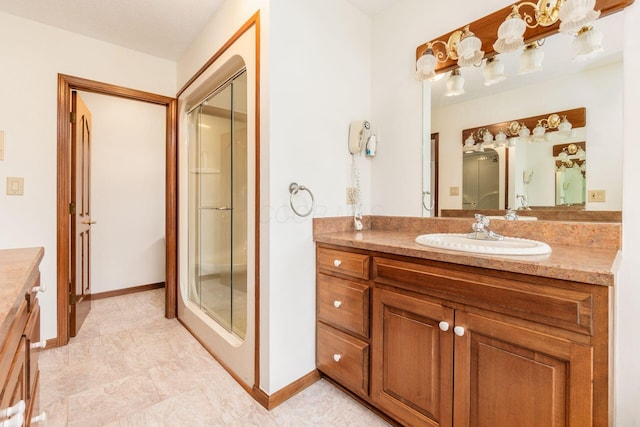 bathroom featuring a shower with door and vanity