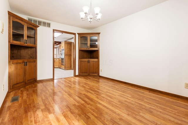 interior space with a notable chandelier and light hardwood / wood-style flooring