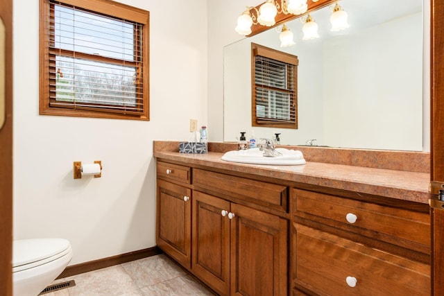 bathroom with tile patterned flooring, vanity, and toilet