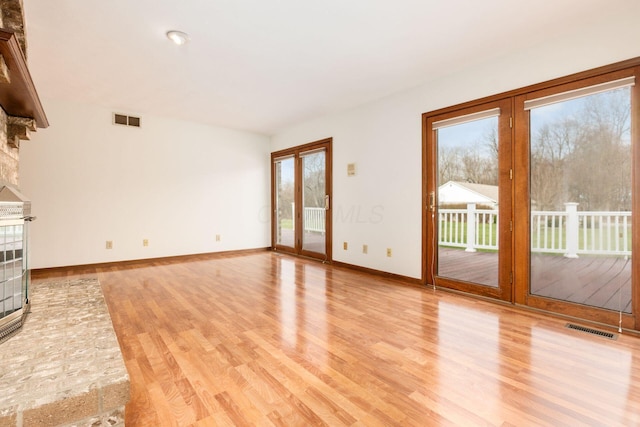 unfurnished living room with a fireplace and light wood-type flooring