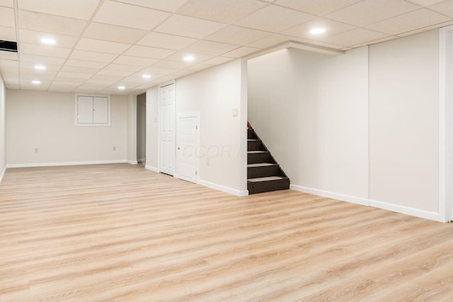 basement with light wood-type flooring and a drop ceiling