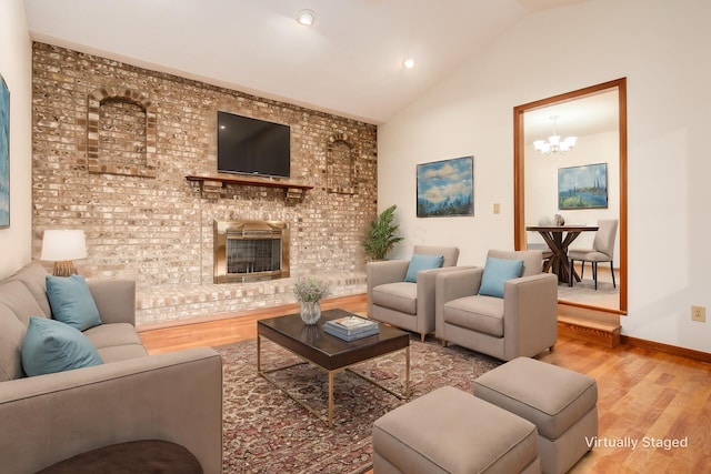 living room featuring hardwood / wood-style flooring, an inviting chandelier, and vaulted ceiling