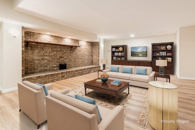 living room with built in features, light hardwood / wood-style flooring, and brick wall