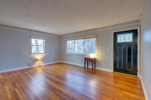 foyer entrance with hardwood / wood-style floors and a textured ceiling