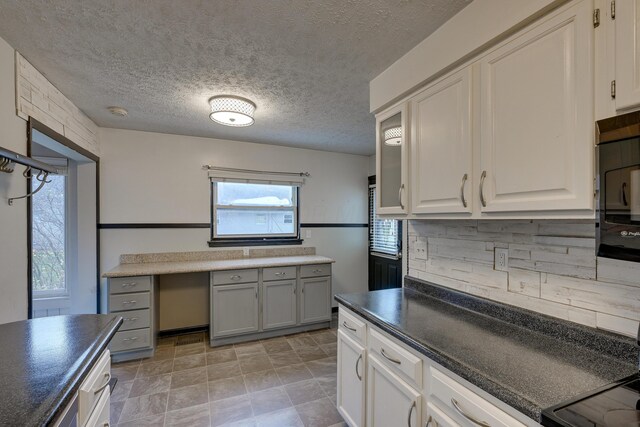 kitchen with white cabinetry, decorative backsplash, and a textured ceiling