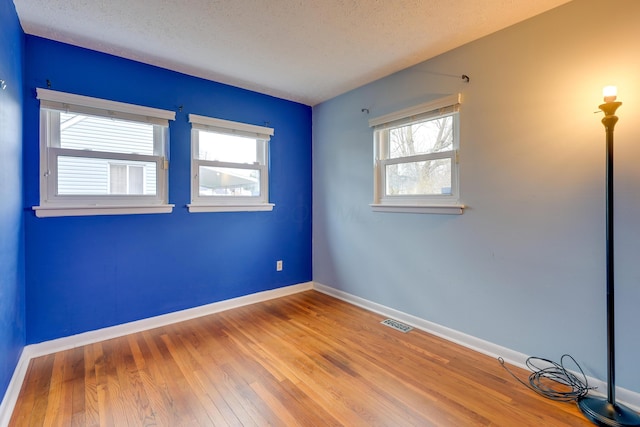 spare room with wood-type flooring and a textured ceiling