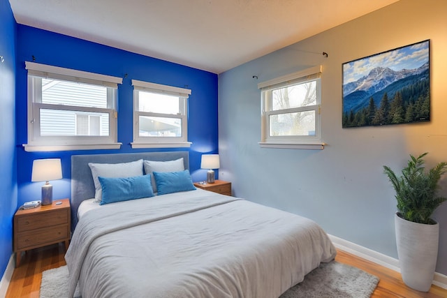 bedroom with wood-type flooring and multiple windows