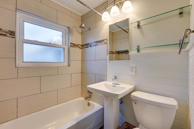 bathroom with toilet, tile walls, and tiled shower / bath