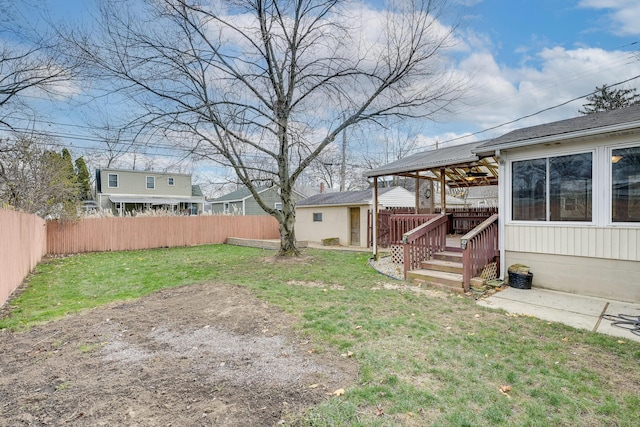 view of yard with a deck and ceiling fan