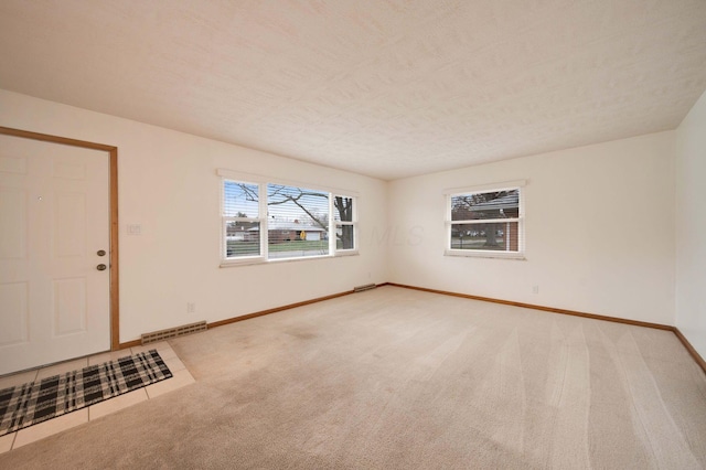 carpeted empty room with a textured ceiling