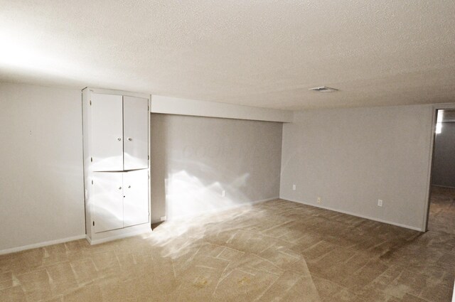 basement featuring carpet and a textured ceiling