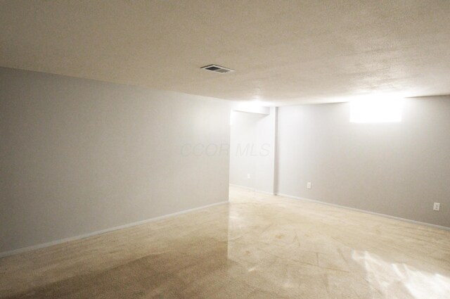 unfurnished room with a textured ceiling and carpet floors