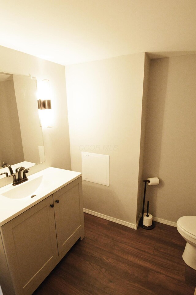 bathroom with vanity, toilet, and wood-type flooring