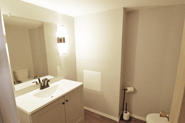 bathroom with vanity, hardwood / wood-style flooring, and toilet