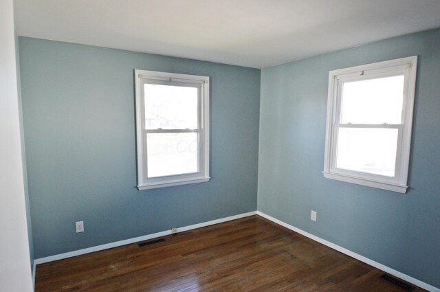 empty room with dark wood-type flooring