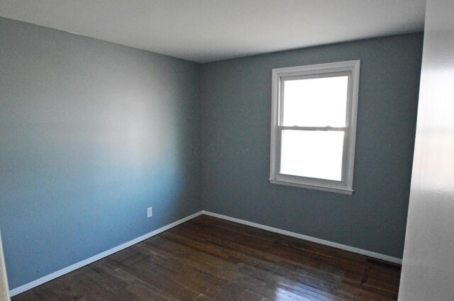 spare room with dark hardwood / wood-style floors