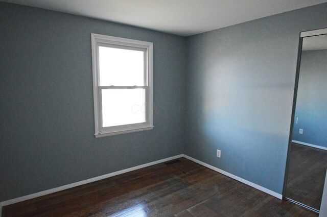 spare room with dark hardwood / wood-style flooring