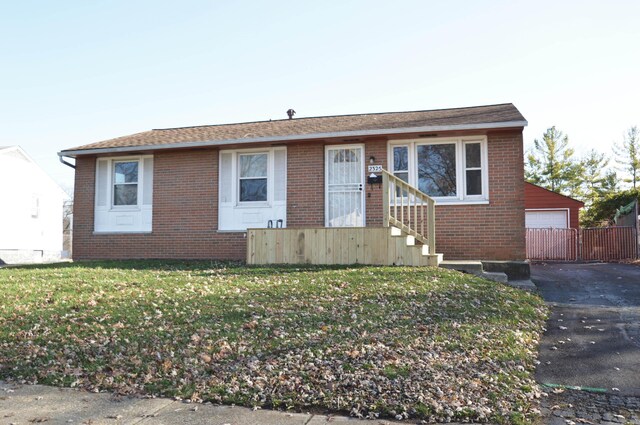 view of front of house featuring an outbuilding, a front yard, and a garage