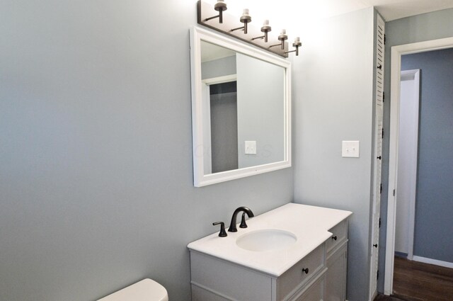 bathroom featuring wood-type flooring, vanity, and toilet