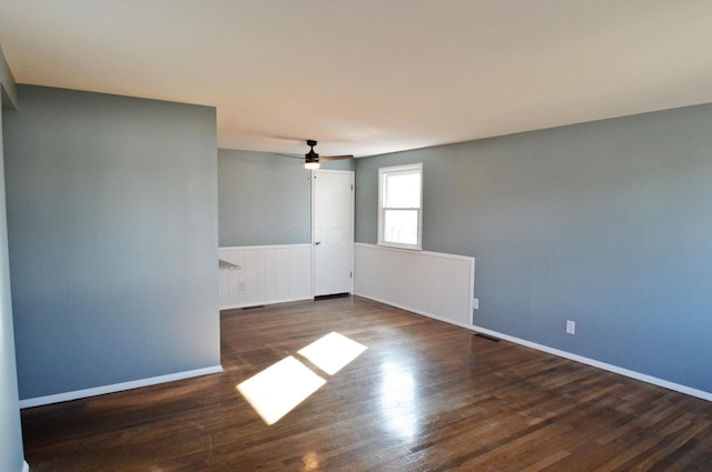 empty room with ceiling fan and dark hardwood / wood-style floors