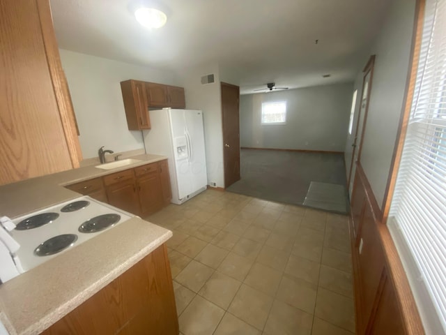 kitchen featuring white appliances, sink, ceiling fan, light tile patterned floors, and kitchen peninsula