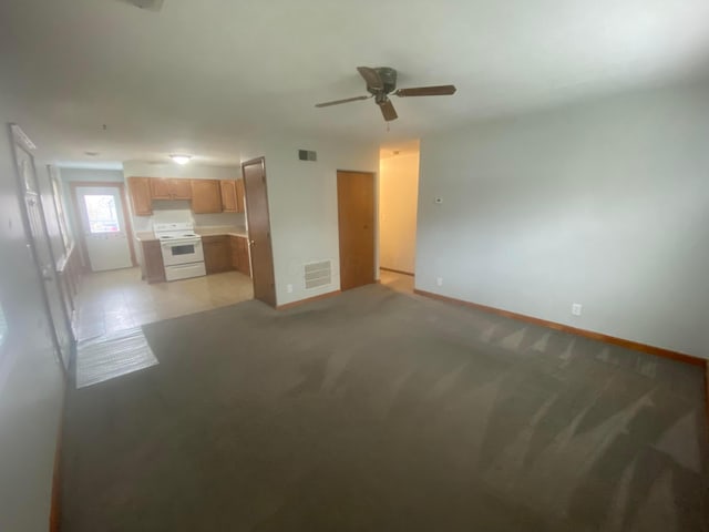 unfurnished living room featuring ceiling fan and light carpet