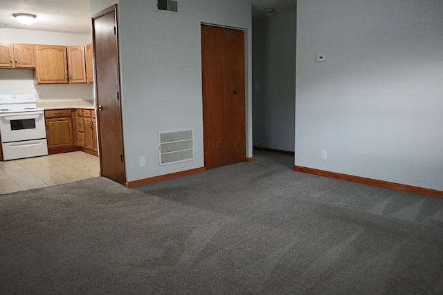 kitchen with white electric stove and light carpet