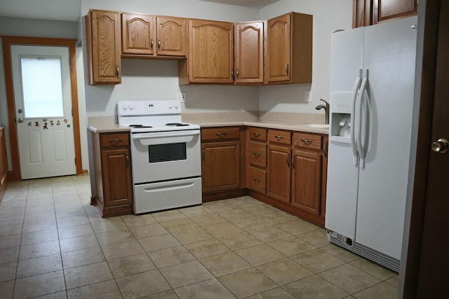 kitchen with sink, light tile patterned floors, and white appliances