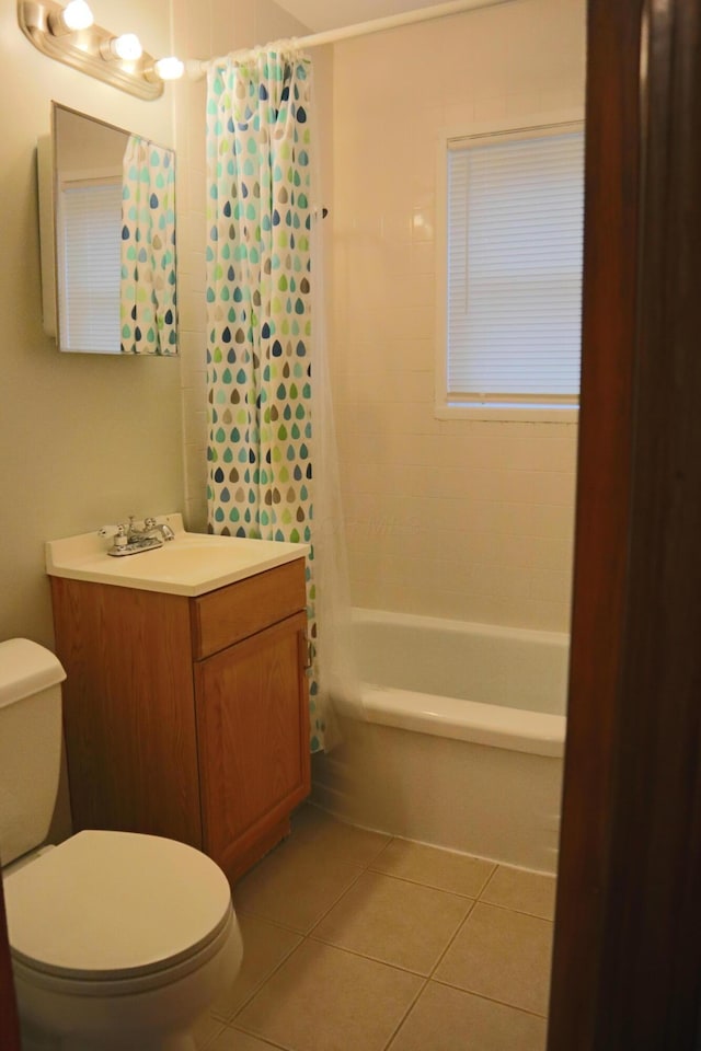 full bathroom with tile patterned floors, shower / bath combo with shower curtain, vanity, and toilet