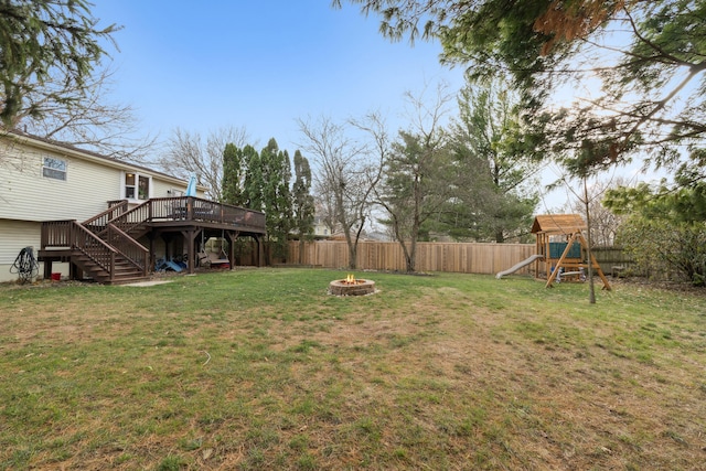 view of yard with a playground, an outdoor fire pit, and a wooden deck