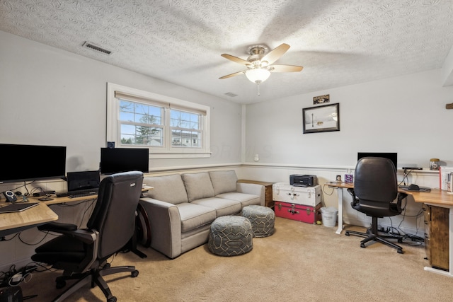 carpeted office with ceiling fan and a textured ceiling