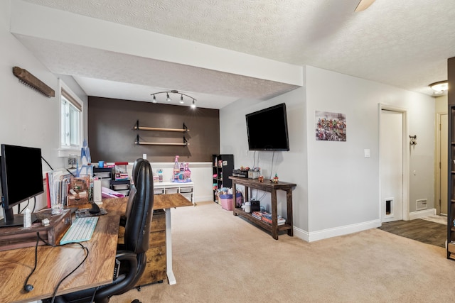 carpeted office with track lighting and a textured ceiling