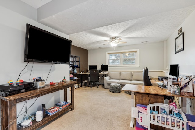 office area featuring a textured ceiling, ceiling fan, and light carpet