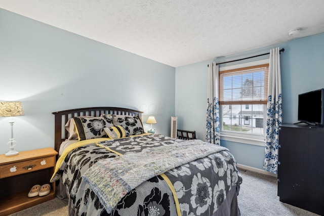 bedroom featuring light colored carpet and a textured ceiling