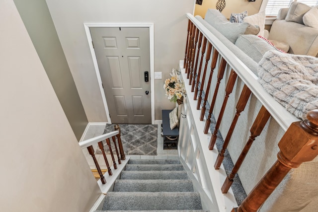 stairway featuring carpet flooring