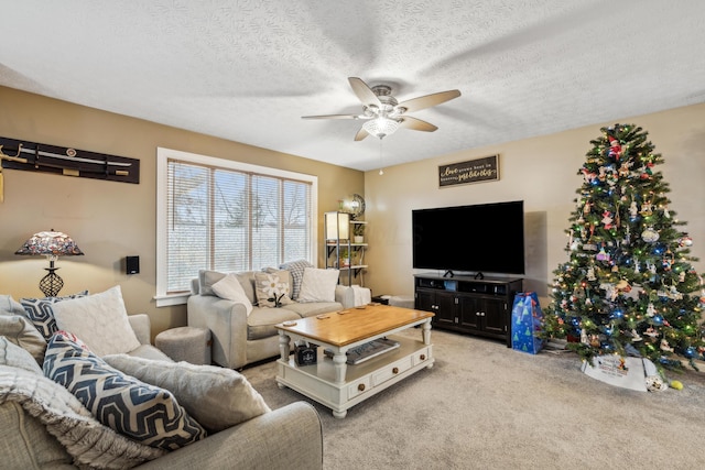 carpeted living room featuring ceiling fan and a textured ceiling