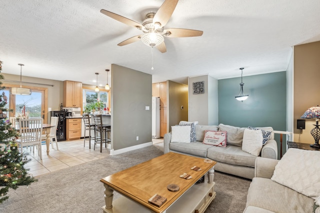 living room featuring light tile patterned floors, a textured ceiling, and ceiling fan