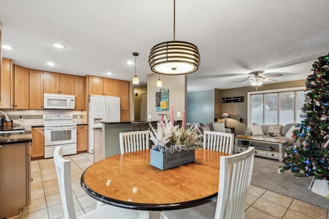 dining space with a textured ceiling, ceiling fan, light tile patterned floors, and sink