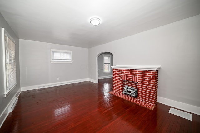 unfurnished living room featuring dark hardwood / wood-style flooring and baseboard heating