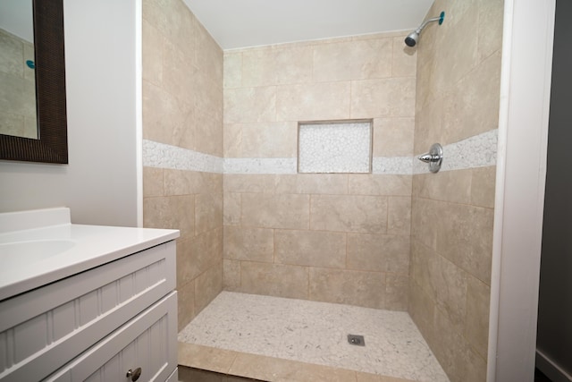 bathroom with vanity and a tile shower