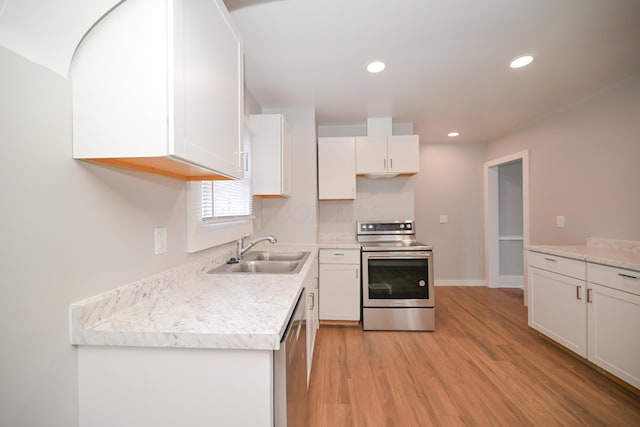 kitchen featuring white cabinetry, sink, stainless steel appliances, and light wood-type flooring