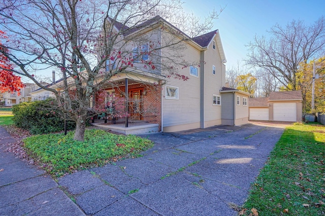 view of front of house with an outbuilding, covered porch, and a garage