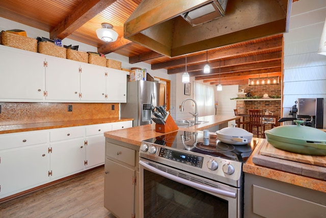 kitchen with pendant lighting, white cabinetry, stainless steel appliances, and beamed ceiling